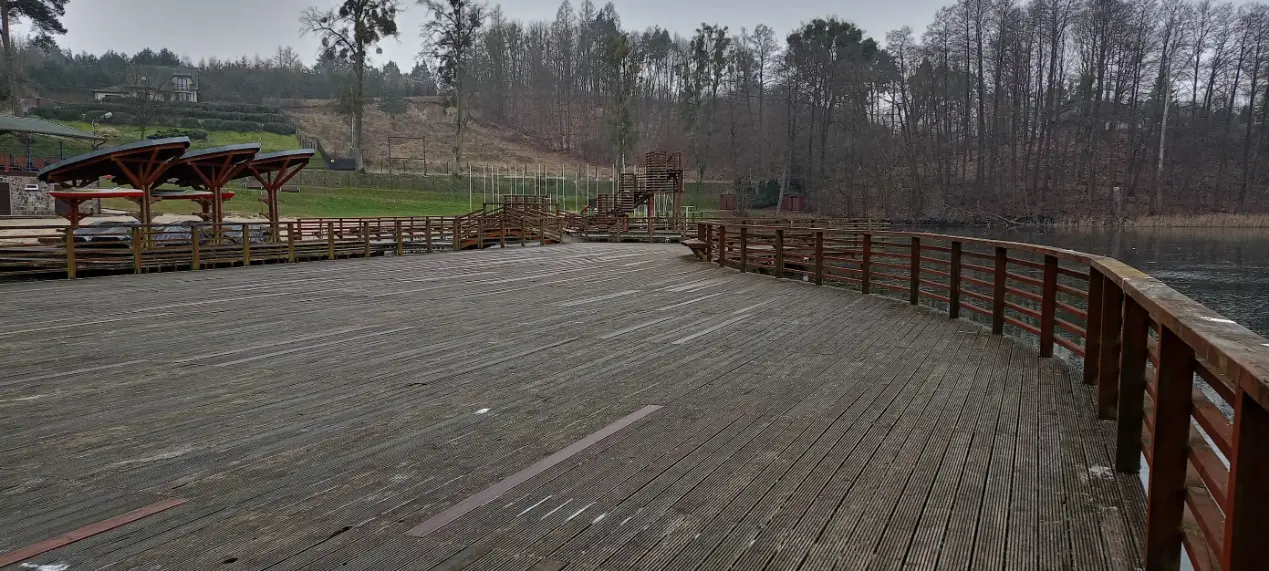 Pomost nad Jeziorem Górznieńskim - widok na turkusową wodę i lasy w tle